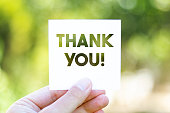 istock Holding the paper with Thank You message in front of a beautiful blur nature background 1262143374