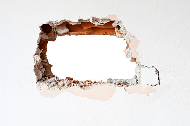 A hole in a brick wall surrounded by white hole formed before renovation of house hole stock pictures, royalty-free photos & images