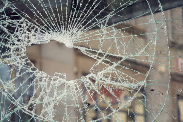 Hole in broken shattered security glass, insurance security crime concept Hole in broken shattered security glass, insurance, security, vandalism or crime concept vandalism stock pictures, royalty-free photos & images