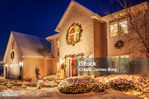 istock Holiday decorated home at evening with Christmas lighting, fluffy snow 629653292