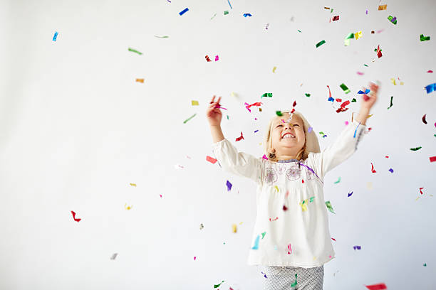 Holiday excitement Ecstatic little girl catching falling confetti new years eve girl stock pictures, royalty-free photos & images