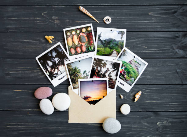 Holiday memories: photos, stones, seashells, fruits on travel photo. Flat lay, top view Holiday resort memories: photos, stones, seashells, citrus fruits on black vintage wooden background. Travel photo, tropic vacation memories. Flat lay, top view souvenir stock pictures, royalty-free photos & images