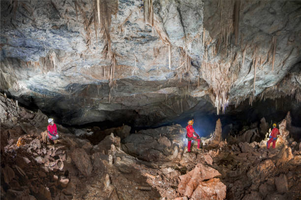 Hollow Deer Gorges Pale, Umbria Italy - June 29, 2017: The Gole del Cervo cave is located on the mountain of Pale in the vicinity of Colfiorito. After the first and long entrance slide, the speleologists, as shown in the photo, come to a large room of about 100 meters. In this case the image highlights the large vault of the ceiling that descends towards the bottom with its innumerable concretions. geologist stock pictures, royalty-free photos & images