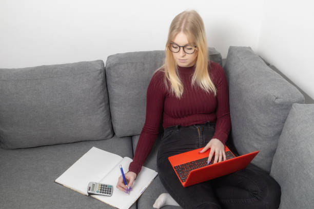 Home bills concept. Young woman pay bills or taxes stock photo