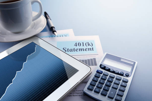 Home Finances 401K Statement A digital tablet with a stock market chart on its screen rests on top of a 401(k) statement that sits on a desktop.  A fountain pen, a calculator, and cup of coffee also frame the scene. 401k stock pictures, royalty-free photos & images