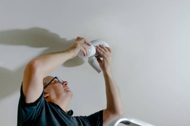 Home improvement - Man changing lightbulb at home stock photo