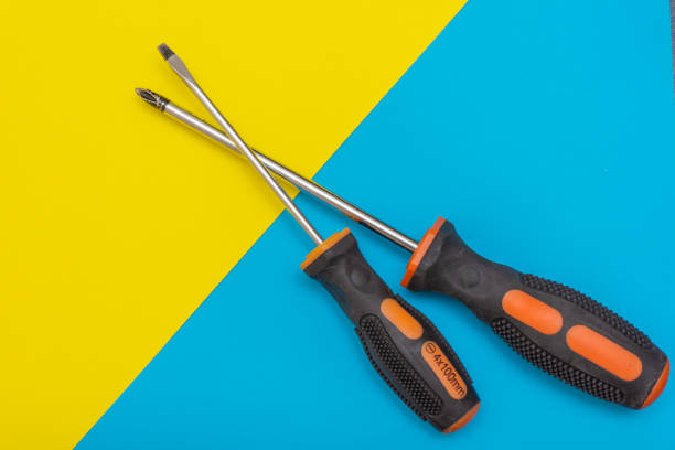 Home improvement: two screwdrivers (philips and slotted) on a blue and yellow flat lay background with copy space. stock photo
