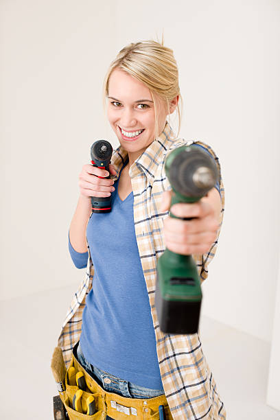 Home improvement - woman with battery screwdriver stock photo