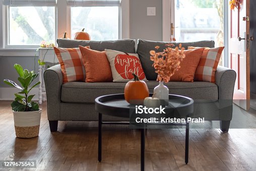 istock Home interior decorated for fall with orange accent pillows on the sofa 1279675543