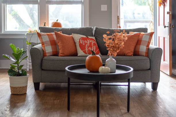 Home interior decorated for fall with orange accent pillows on the sofa Happy fall throw pillow on the sofa for autumn season home decor home decor stock pictures, royalty-free photos & images
