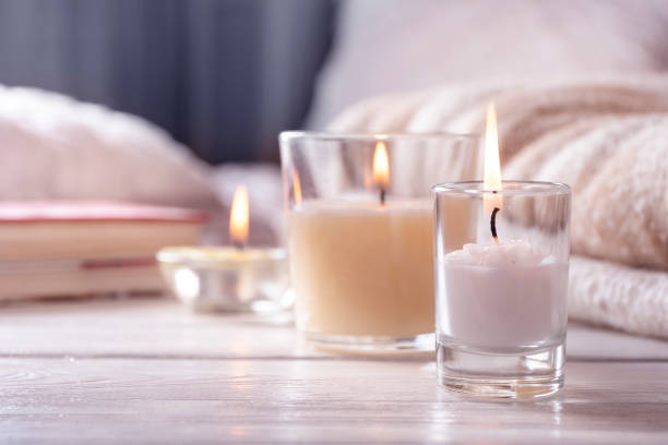 Home interior. Still life with detailes. Several candles on white wooden table in front of bed, the concept of cosiness. Home interior. Still life with detailes. Several candles on white wooden table in front of bed, the concept of cosiness. Close up. candle stock pictures, royalty-free photos & images