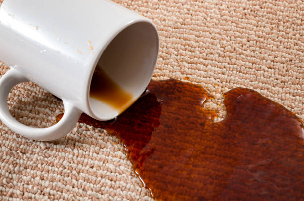 Home mishap, stained carpet, and domestic accident concept with close up of a spilled cup of coffee leaving a stain on the brown carpet Home mishap, stained carpet, and domestic accident concept with close up of a spilled cup of coffee leaving a stain on the brown carpet spilling stock pictures, royalty-free photos & images