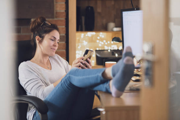 Home Office Coffee Break A woman is working from a home office.  A woman is taking a break from work. comfy work furniture stock pictures, royalty-free photos & images