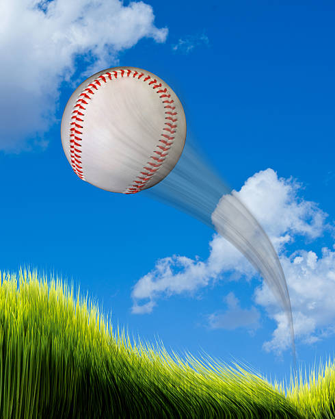Home Run Baseball. Baseball flying high and fast over green grass. home run stock pictures, royalty-free photos & images