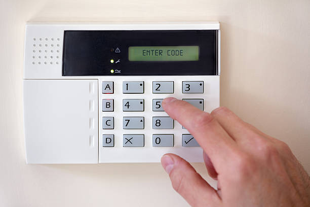 Home security Security alarm keypad with person arming the system burglar alarm stock pictures, royalty-free photos & images