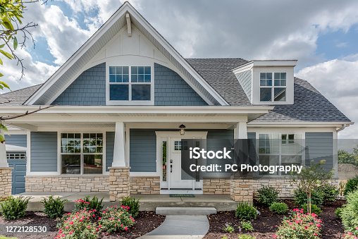 istock Home with blue siding and stone façade on base of home 1272128530