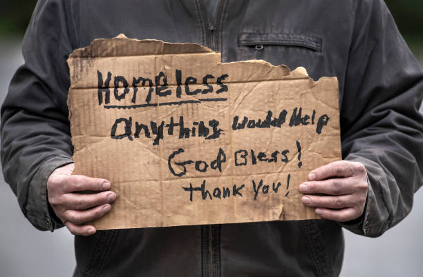 Homeless cardboard sign held by man, God bless stock photo