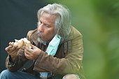 istock Homeless man portrait eating bread. 1342200199