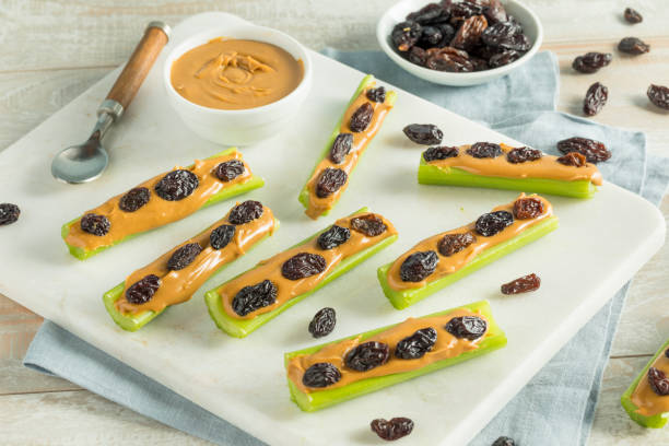 Homemade Ants on a Log Snack Homemade Ants on a Log Snack with Celery Peanut Butter and Raisins celery stock pictures, royalty-free photos & images