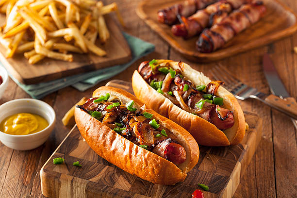 Homemade Bacon Wrapped Hot Dogs Homemade Bacon Wrapped Hot Dogs with Onions and Peppers sausage stock pictures, royalty-free photos & images