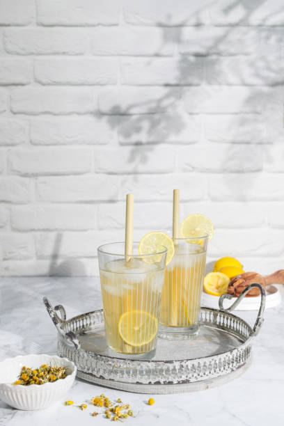 Homemade chamomile and lemon ice tea with bamboo straws stock photo
