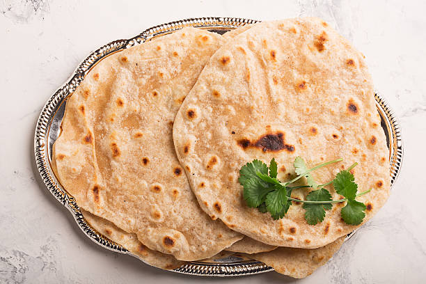 Homemade chapati (Indian bread) Homemade chapati (Indian bread) served with almond and masala tea chapatti stock pictures, royalty-free photos & images