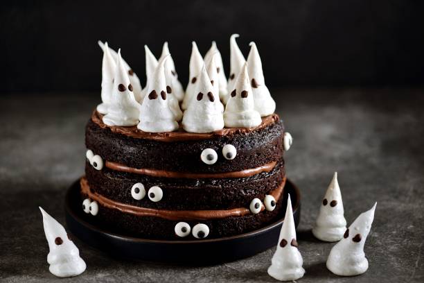 Homemade Chocolate Cake with Chocolate cream and Meringue Ghost and Eyes for Halloween Party. stock photo