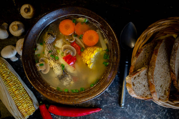 homemade cod soup and rye bread on dining table stock photo