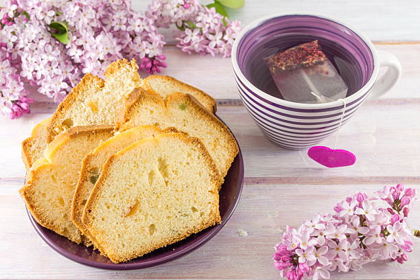 Homemade fruit bread with tea Homemade fruit bread slices with spring flowers and tea papaya cake stock pictures, royalty-free photos & images