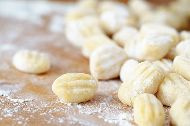Homemade gnocchi on a flour-covered, wood surface stock photo
