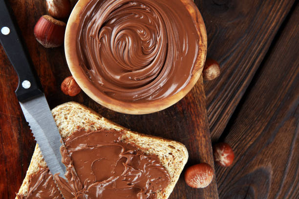 Homemade hazelnut spread with toast and in wooden bowl for breakfast. Hazelnut Nougat cream stock photo