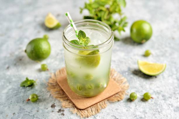 Homemade healthy non-alcoholic cocktail Mojito from green gooseberry, lime and mint. stock photo