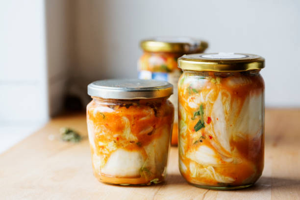 Homemade Kimchi in glass jar on kitchen board stock photo