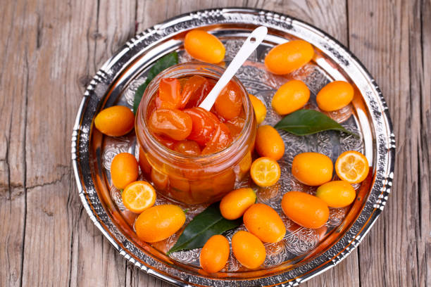 Homemade kumquat jam in jar and fresh kumquats, top view Homemade kumquat jam in jar and fresh kumquats, top view kumquat stock pictures, royalty-free photos & images