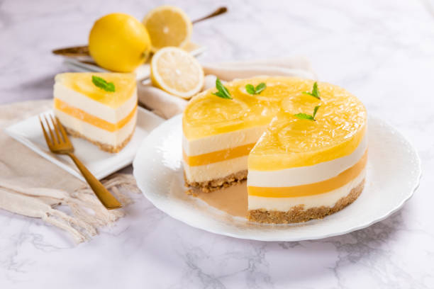 Homemade Layered Lemon Cheesecake isolated on marble background stock photo