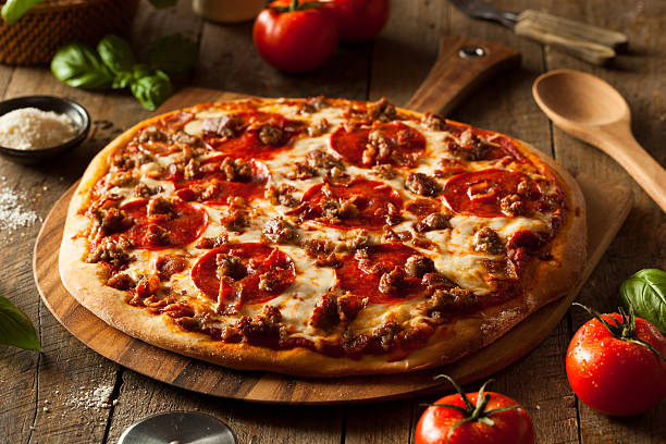 Homemade Meat Loves Pizza Homemade Meat Loves Pizza with Pepperoni Sausage and Bacon dessert topping stock pictures, royalty-free photos & images