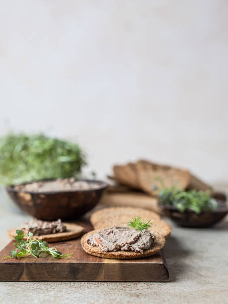 Homemade meat or chicken liver pate with multigrain crackers and microgreen, concrete background. stock photo