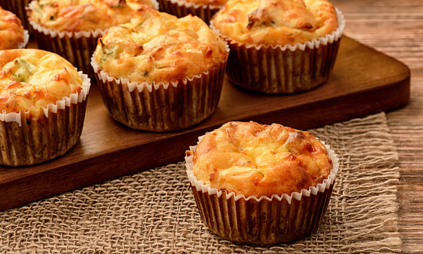 Homemade muffins with chicken and cheese on brown wooden board. stock photo