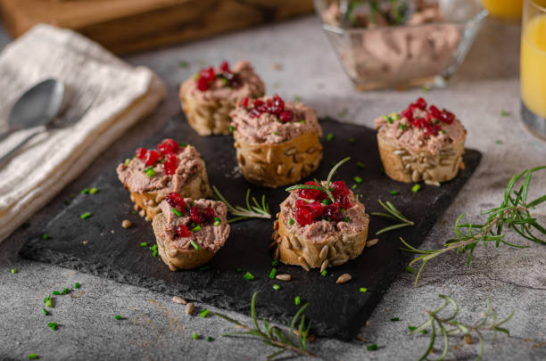 Homemade pate on heathy bread with cranberries Delicious homemade pate with wholegrain pastry and herbs crostini photos stock pictures, royalty-free photos & images