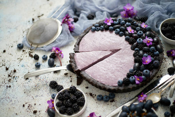 Homemade piece of delicious blueberry, blackberry and grape pie cut from a tart served on table stock photo