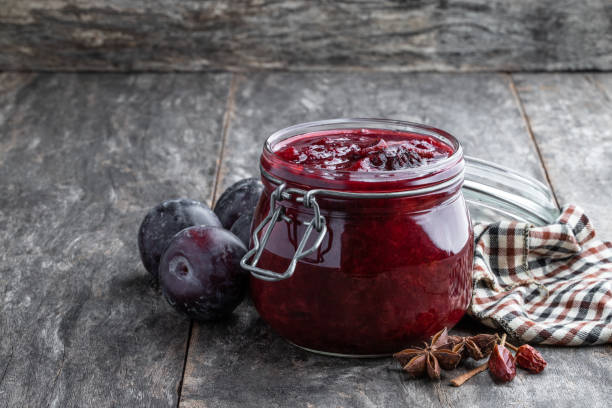 Homemade plum chutney in glass jar on wooden table Homemade  plum chutney in glass jar on wooden table chutney stock pictures, royalty-free photos & images