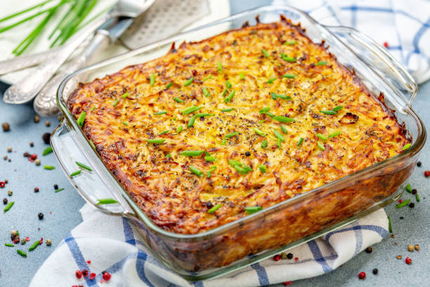 Homemade potato casserole kugel. Glass pan with traditional potato kugel on wooden serving board, selective focus. casserole stock pictures, royalty-free photos & images