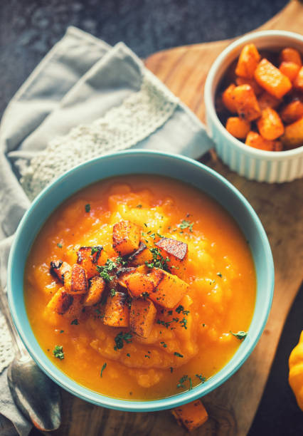 Homemade pumpkin cream soup with baked pumpkin pieces in a  bowl stock photo