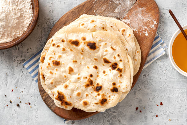 Homemade Roti Chapati Flatbread Homemade Roti Chapati Flatbread on gray concrete background top view. Freshly baked indian flatbread naan bread stock pictures, royalty-free photos & images