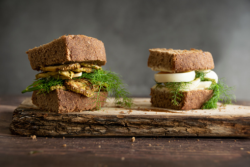 Homemade sandwiches with whole wheat bread, cream goat cheese, eggs, grilled zucchini and raw dill