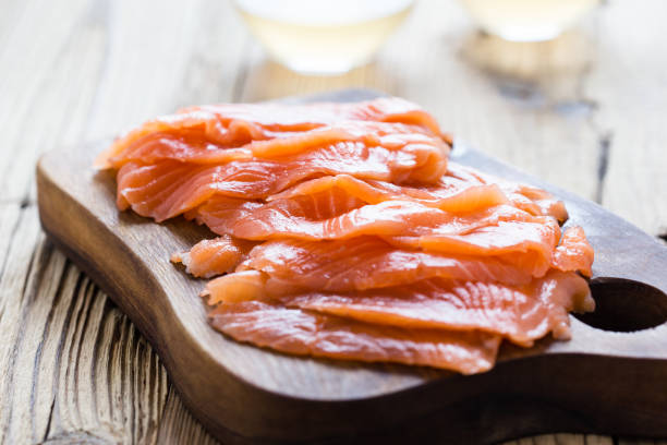 Homemade smoked salmon on wooden board Homemade smoked salmon on wooden board, sliced, close up, selective focus smoked salmon photos stock pictures, royalty-free photos & images