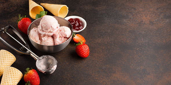 Ingredients for making and serving ice cream with fresh berries, jam and sugar cones on dark vintage background, selective focus.  Healthy summer food concept.