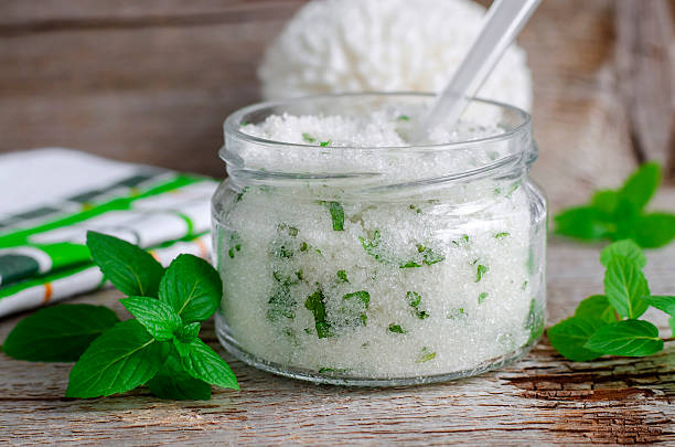 Homemade sugar scrub with mint leaves and essential mint oil Refreshing homemade sugar scrub with vegetable oil, chopped mint leaves and essential mint oil green olives jar stock pictures, royalty-free photos & images