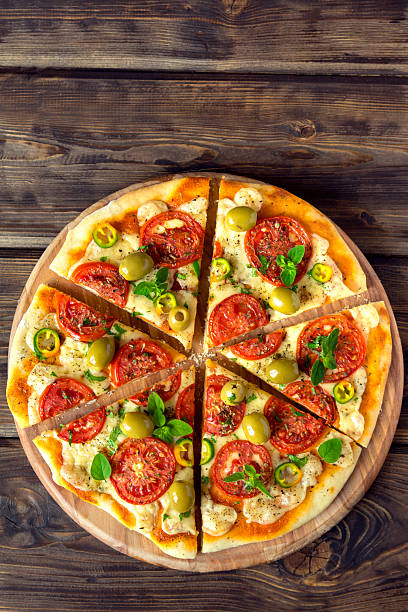 Homemade vegetable pizza with tomatoes, green olives, pepper, basil,...