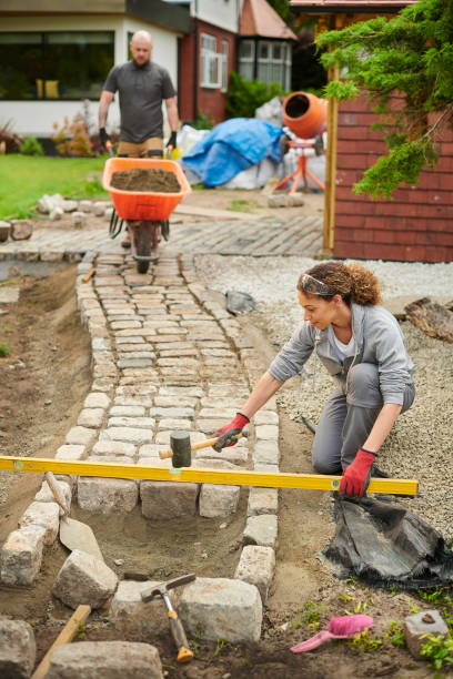 homeowner installing a cobble path stock photo